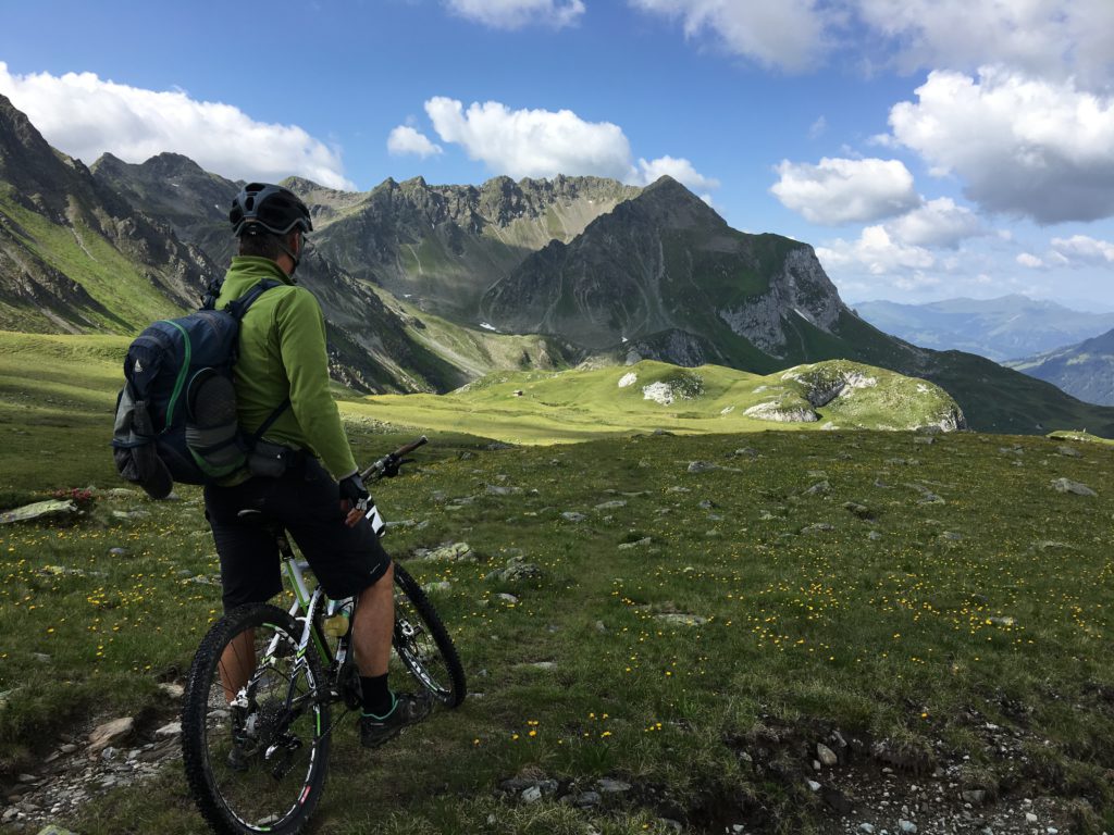 Turisme rural i cicloturisme és una combinació perfecte. Ciclista contemplant el paisatge d'alta muntanya