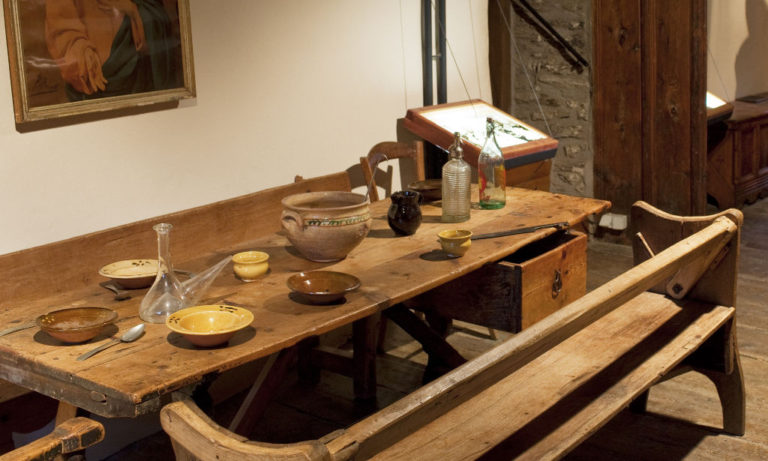Taula de fusta parada amb plats de terrissa, porró i altres estris tradicionals. Ecomuseu de les Valls d'Àneu Foto: Oriol Clavera